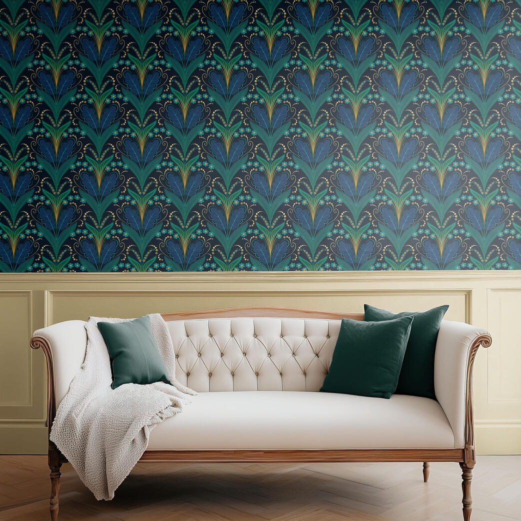Untitled Art Deco-inspired wallpaper with teal, emerald, and navy botanical motifs displayed behind a cream tufted sofa with deep green accent pillows.